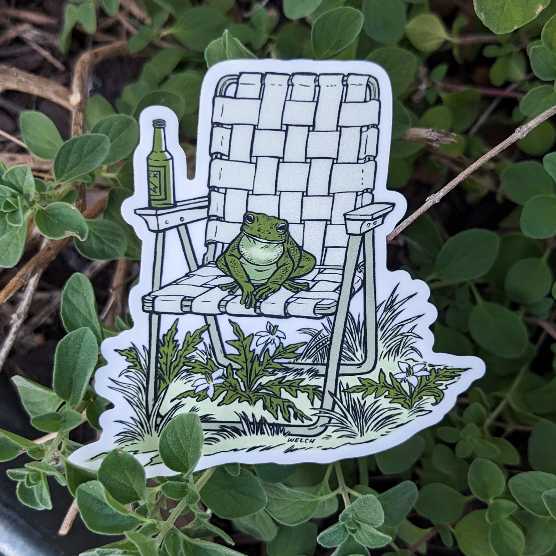 A sticker with an illustration of a frog sitting in a vinyl folding chair. He has a bottle of beer.